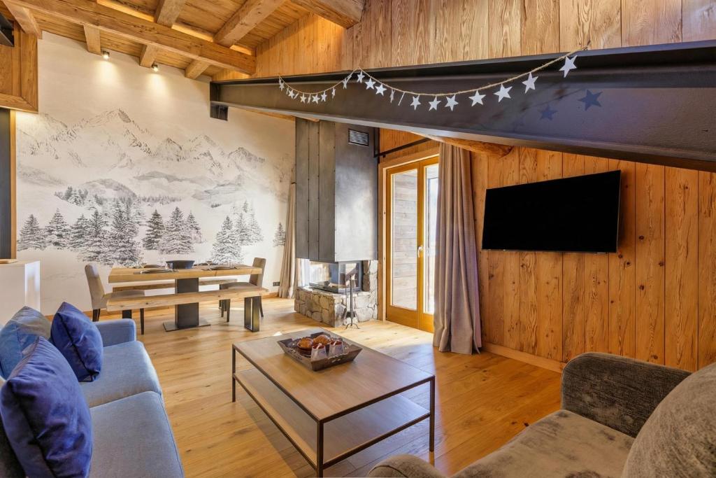 a living room with a couch and a fireplace at La Ferme à Roland Cozy Mountain Style 2BR for 6 Ski In/Ski out - Happy Rentals in Chamonix