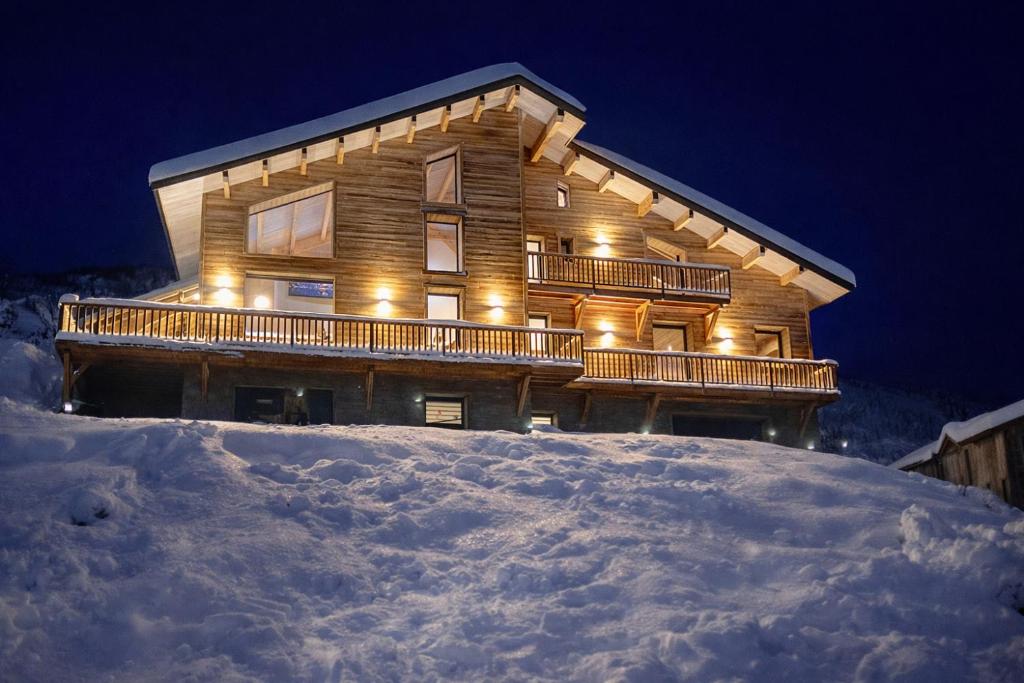 a log cabin in the snow at night at Chalet 1480 in Allos