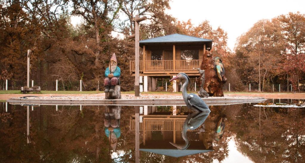 a statue of a woman and a bird in a pond at Pensión Cabañas Bosque Máxico de Bonxe in Outeiro de Rei