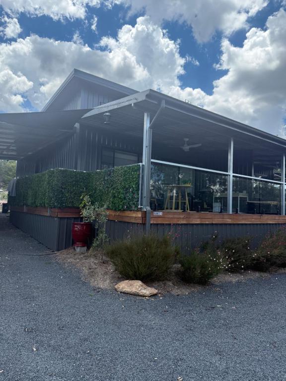 a building with windows and bushes in front of it at Banksia apartment - Escape to Serene Rural Bliss! in Inverell