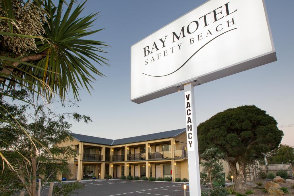 a sign in front of a bay world shopping hotel at Bay Motel Safety Beach in Safety Beach