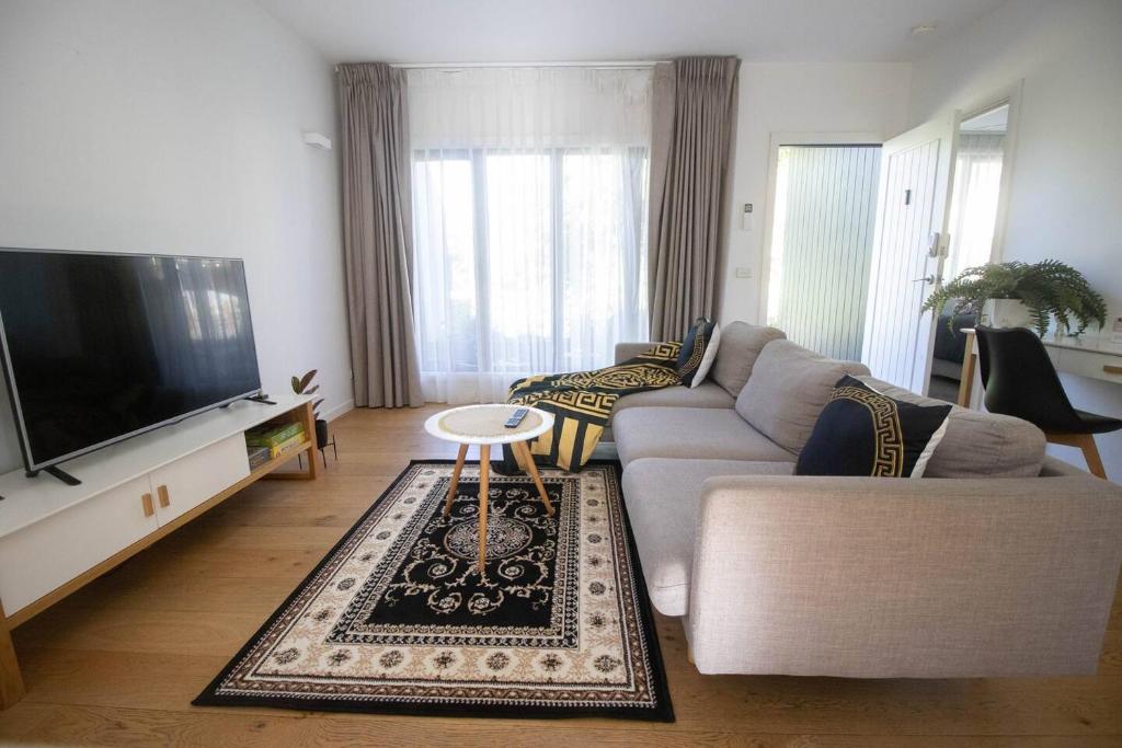 a living room with a couch and a flat screen tv at Lakes Edge 1 - 2BR Close to Lake in Wendouree