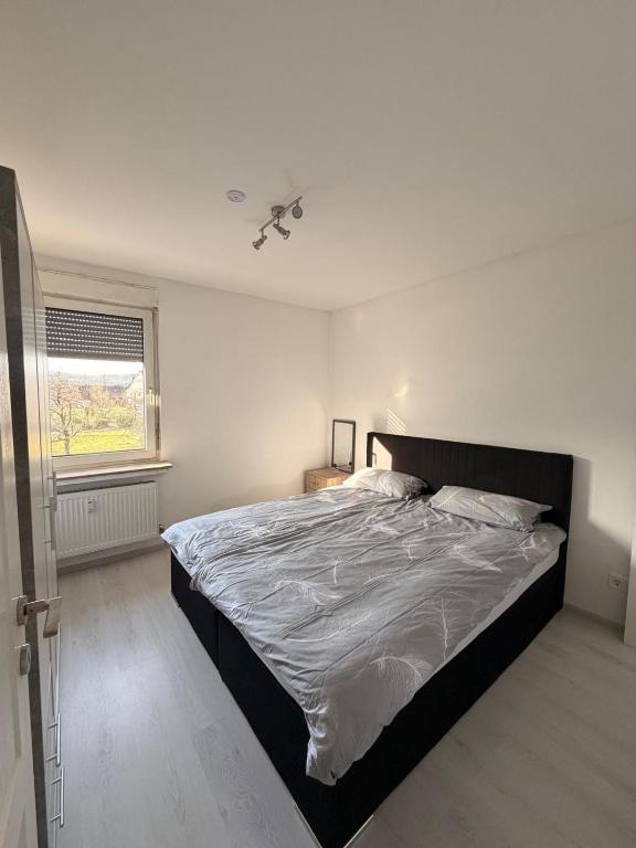 a bedroom with a large bed with a ceiling fan at Kleines Appartment mit großer Terrasse in Herscheid