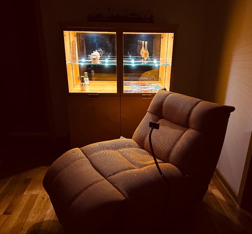 a living room with a chair in front of a window at Senfzimmer mit Balkon in Gerwisch