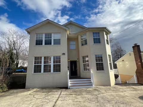 a large white house with a driveway at 25 Lux Room 2 - 1 Queen Bed, Shared Bathroom - Nonsmoking in Arlington
