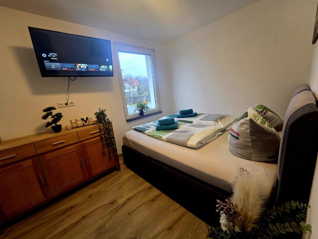 a bedroom with a bed with a flat screen tv on the wall at Ferienhaus am Tänntalbach in Öhrenfeld