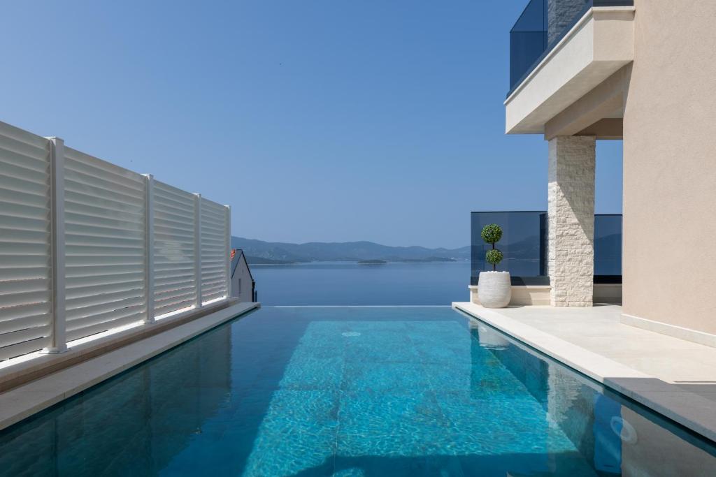 a swimming pool in a house with a view of the water at Villa Sole in Komarna