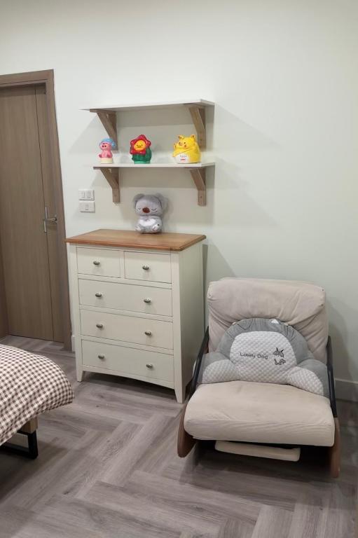 a childs bedroom with a dresser and a chair at Niu Homestay in An Khê