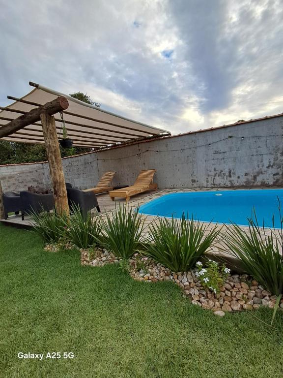 a swimming pool in a yard with a patio at Refúgio dos Sonhos in Gonçalves