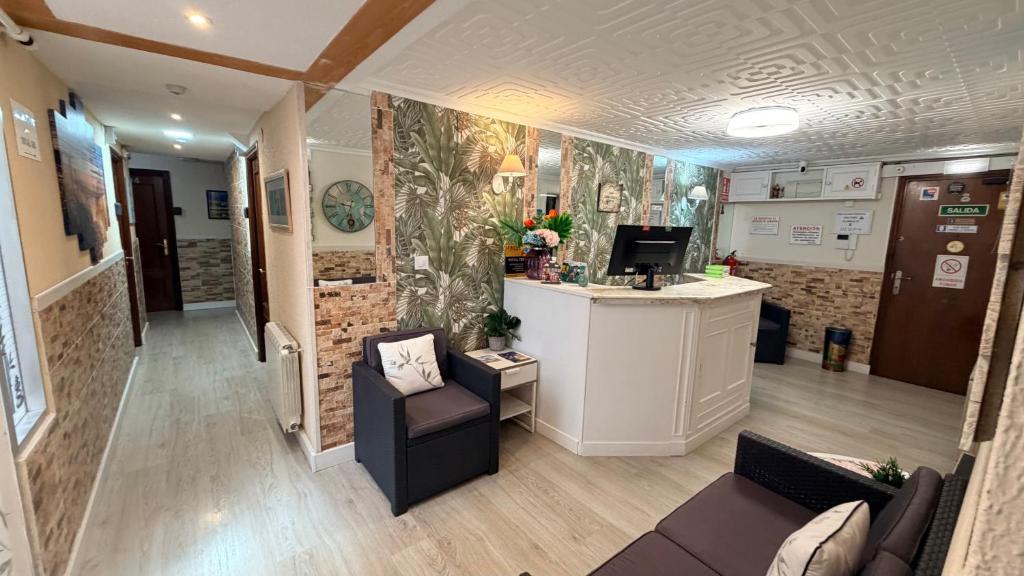 a room with a bar with a couch and a tv at Verdemar Rooms in Gijón