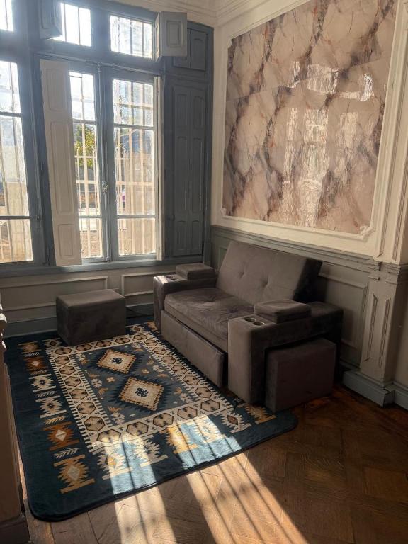a living room with a couch and a rug at hostel family in Santiago