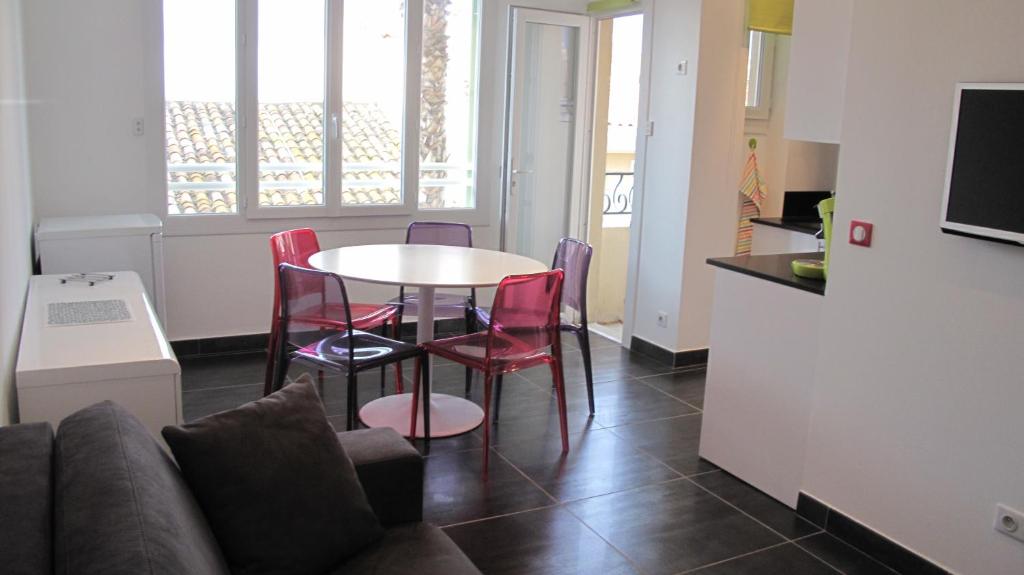 een keuken en een tafel en stoelen in een kamer bij L'excelsior in Bandol