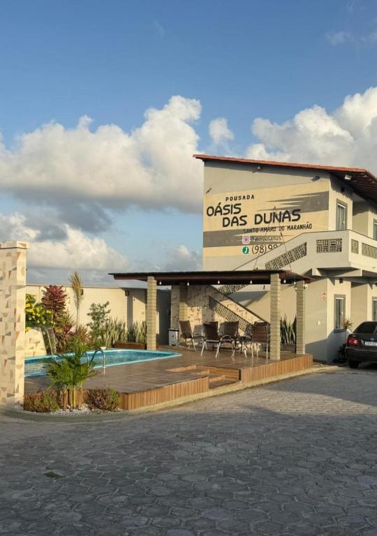 a building with a swimming pool in front of it at Pousada Oásis das Dunas in Santo Amaro