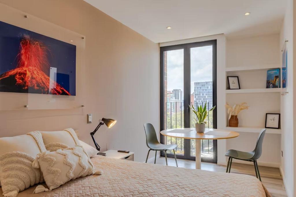 a bedroom with a bed and a table with chairs at Studio Apartment Zona 10 near airport in Estación Pamplona