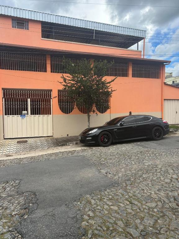 a black car parked in front of a building at Casa BIG John 4 Bahia in Divinópolis