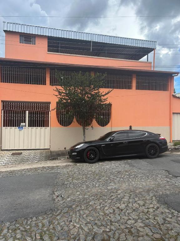 a black car parked in front of a building at Casa BIG John 5 Bahia in Divinópolis