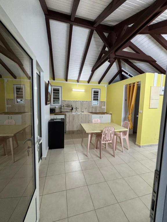 a kitchen with a table and chairs in a room at Bungalow Cécilia in Petit-Bourg