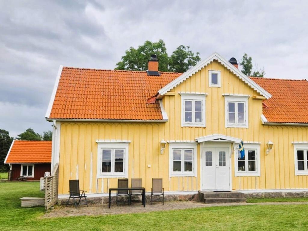 a yellow house with an orange roof at 4 star holiday home in ÖDESHÖG in Ödeshög