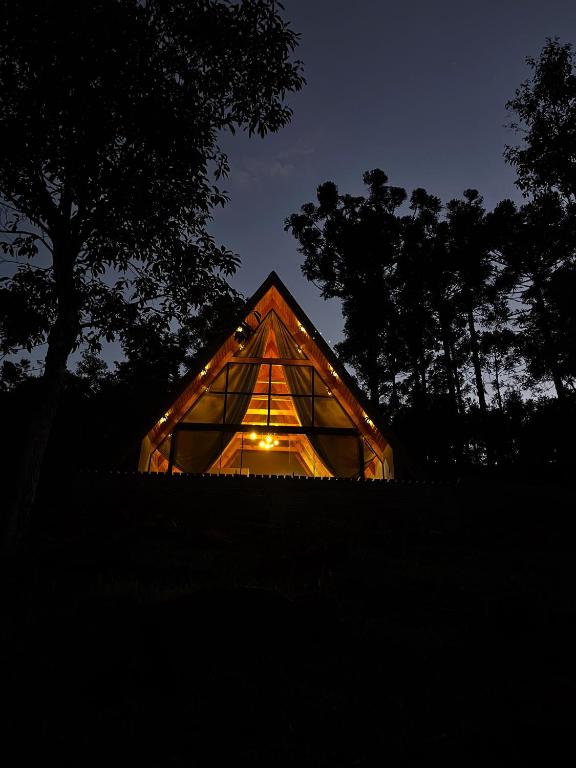 a house with a glass roof at night at Chalé Rio Capetinga 02 in Anchieta