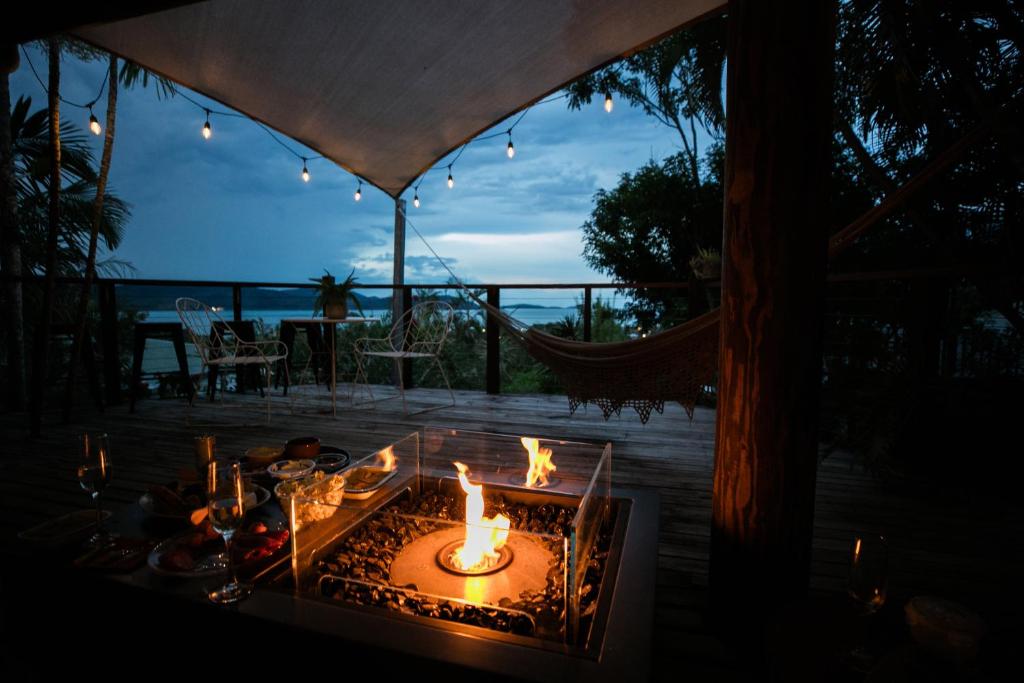 a fire pit on a deck with a view of the ocean at The Nest! in Cannonvale
