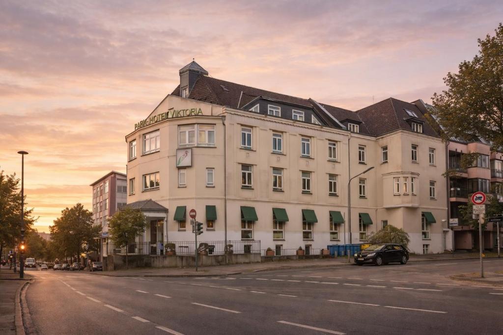 a large white building on the side of a street at Hotel VIKTORIA Düsseldorf-Neuss - Self Check-In in Neuss
