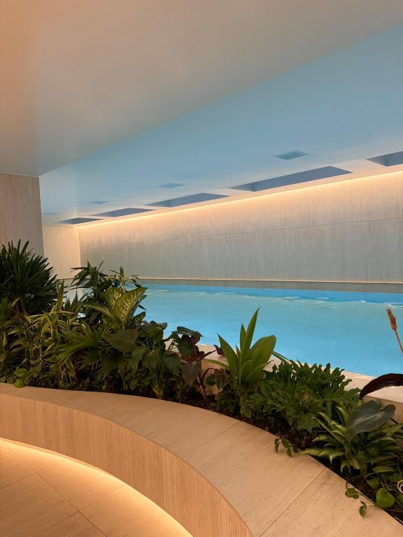 a large swimming pool in a building with plants at Adagio Quito Suite de Lujo in Quito