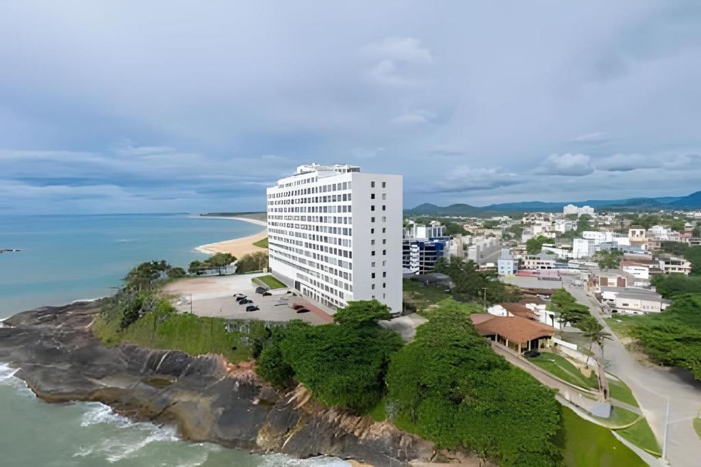 an aerial view of a white building next to the ocean at Guarapari Center Aparts in Guarapari