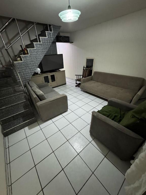 a living room with couches and a staircase at Caruaru house in Caruaru