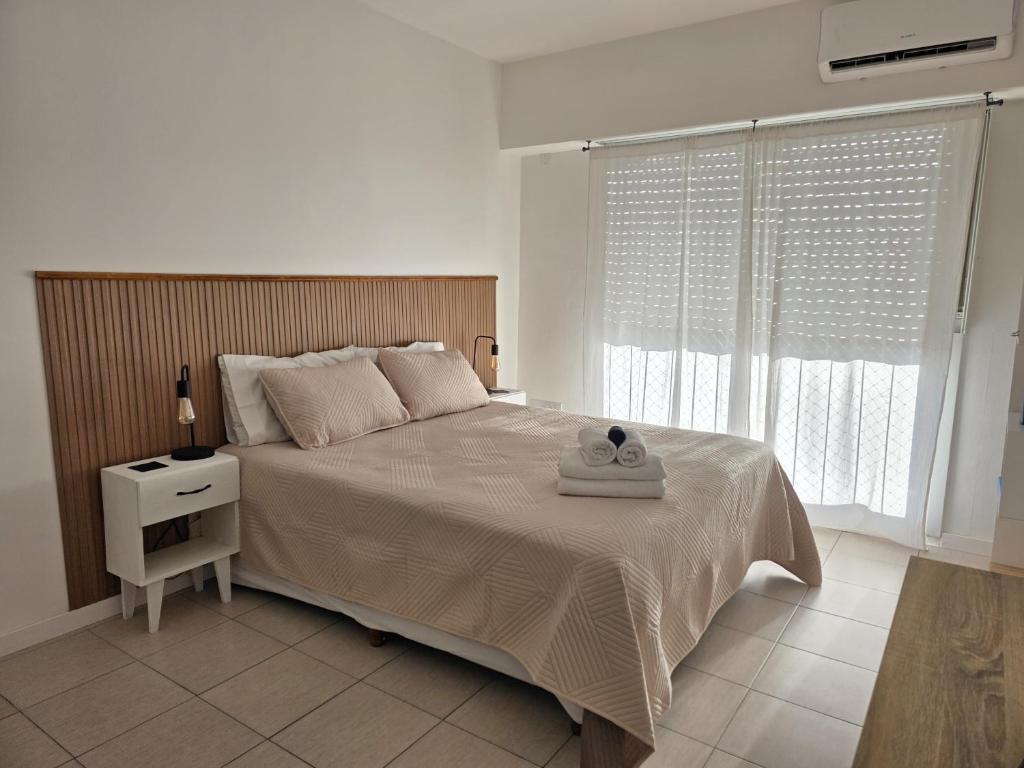 a bedroom with a large bed with a wooden headboard at Luminoso y cálido atardecer in Ramos Mejía