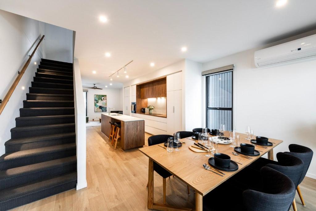 a dining room with a table and chairs and a staircase at Oak & Ivy on Windsor in Williamstown