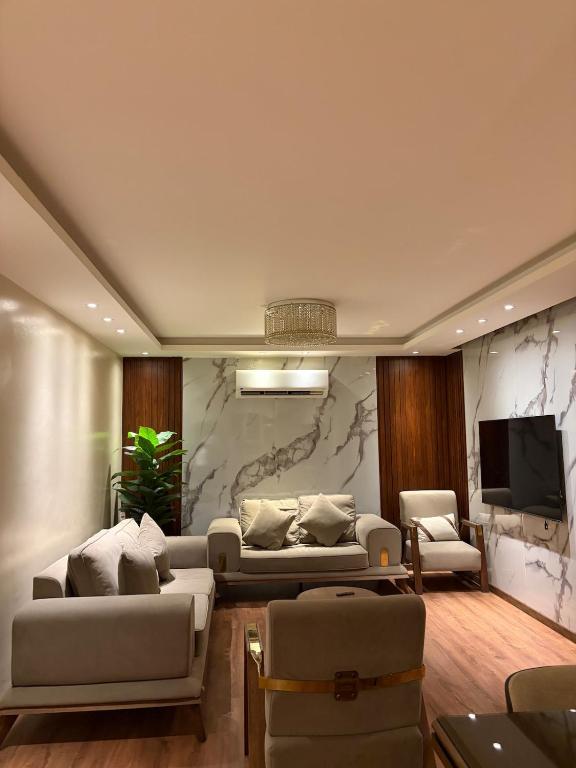 a living room with two couches and a tv at Modern 4BR 3Bath Stylish Spacious in Madinaty