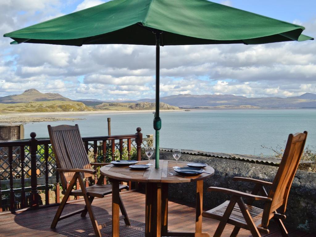 a table with two chairs and an umbrella on a deck at Castle Street in Criccieth