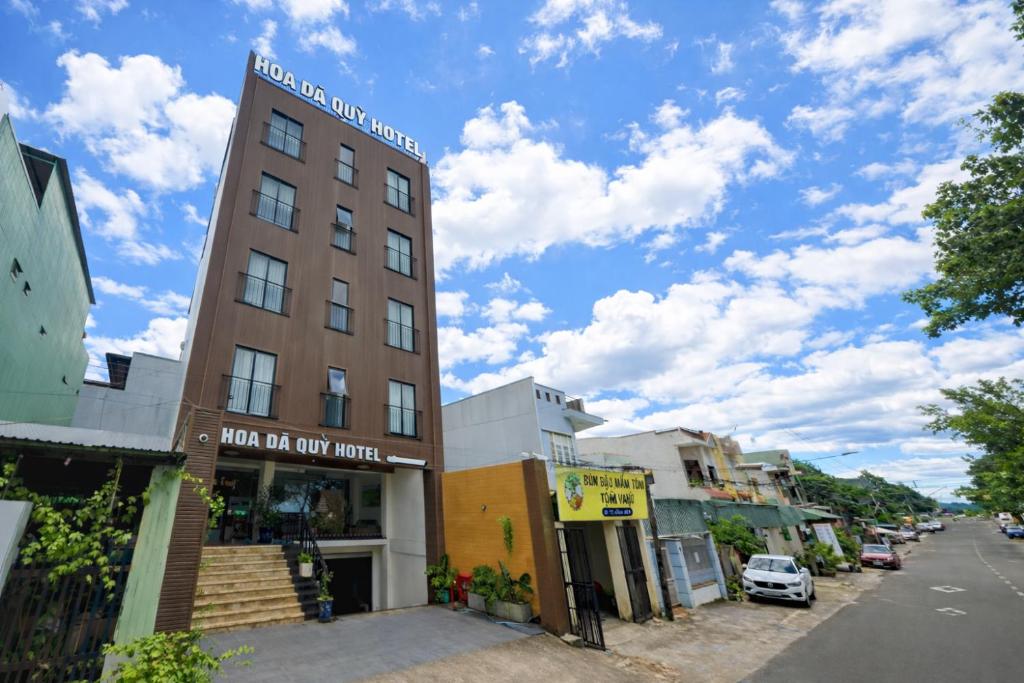 a tall building on a city street with a blue sky at Hoa Dã Quỳ Hotel in Pleiku