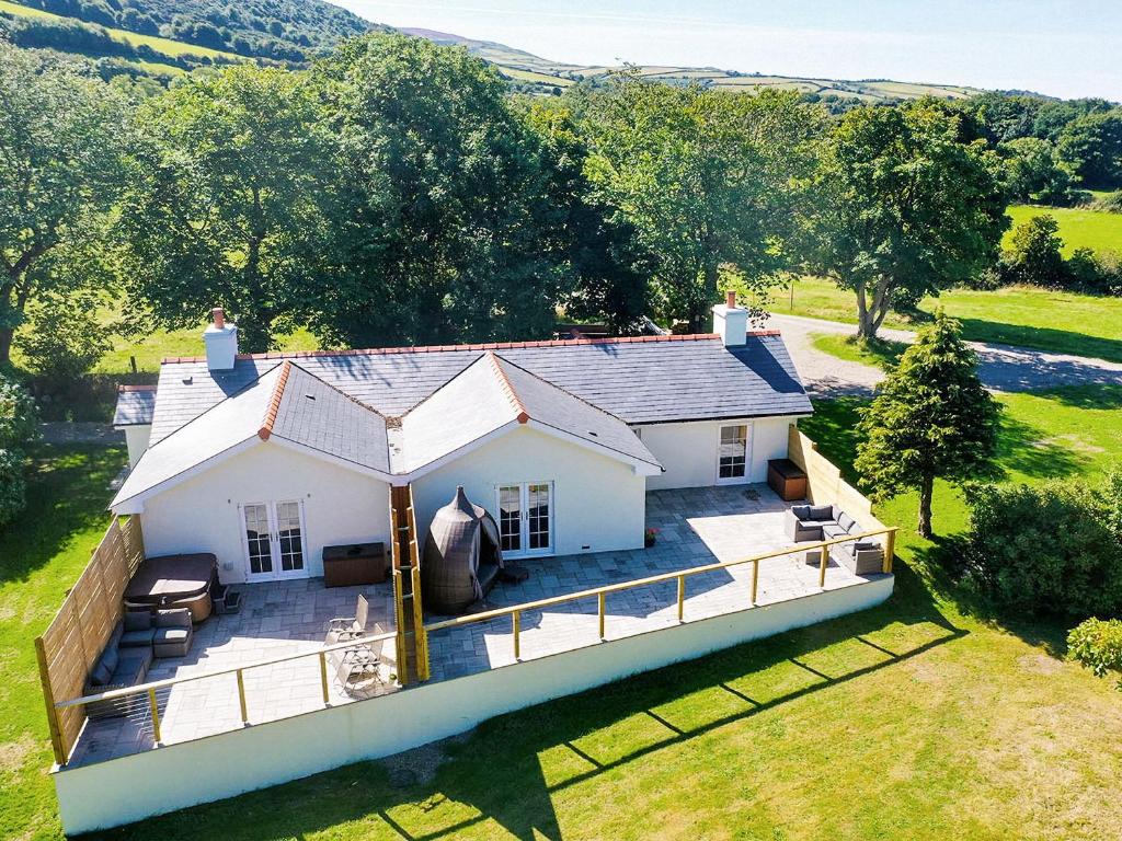 an aerial view of a white house with a yard at Bumblebee Cottage-Uk39918 in Ballakinnag