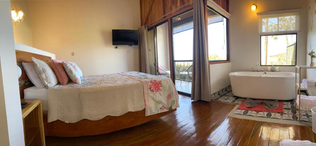a bedroom with a bed and a bath tub and a tub at Villas Flakis, Luna in Monteverde Costa Rica