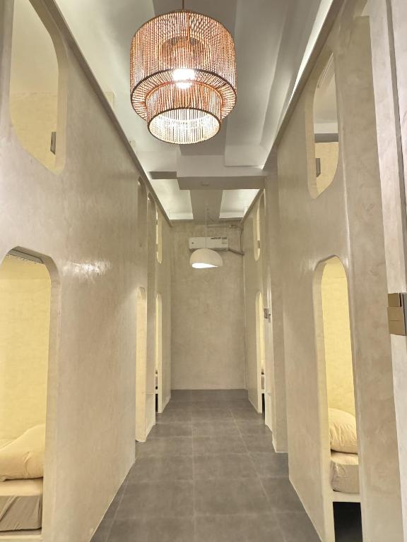 a hallway with beds and a chandelier in a room at Poddwell Siquijor in San Juan