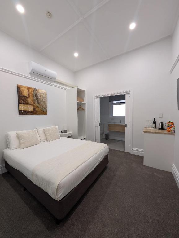a white bedroom with a large white bed in it at Balcony On Sixth Lodge in Murray Bridge