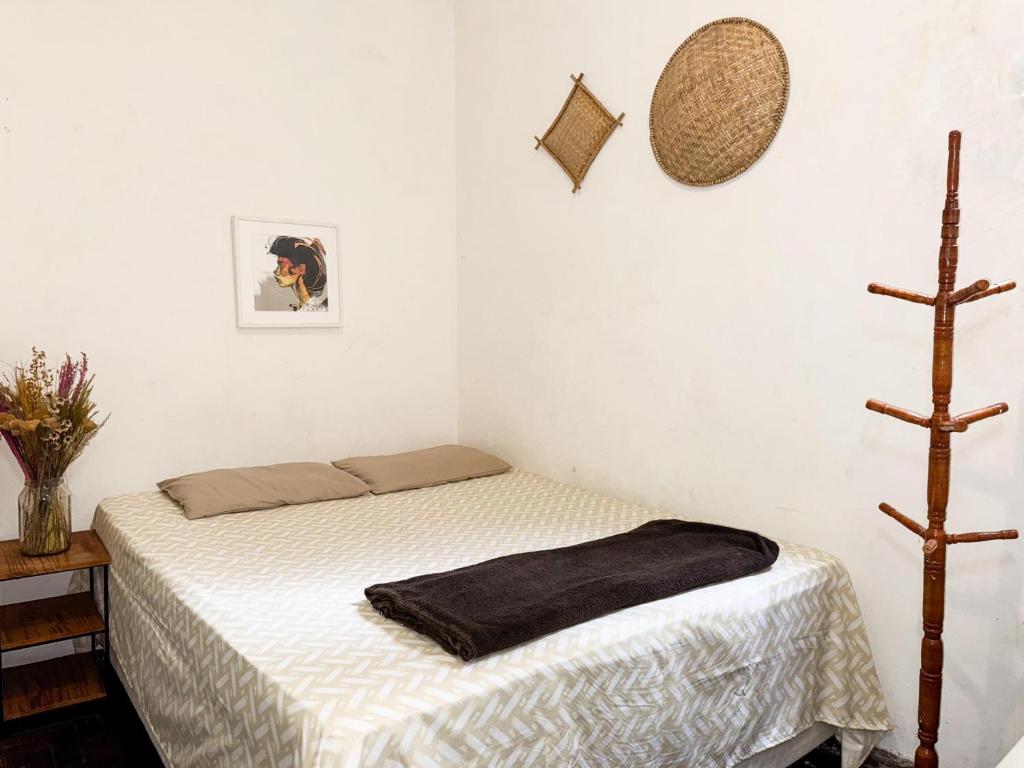 a bedroom with a bed with a black blanket on it at CasaDePretaPelo in Salvador