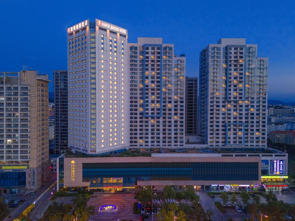 a city skyline with tall buildings at night at Weihai Haiyue Jianguo Hotel in Weihai