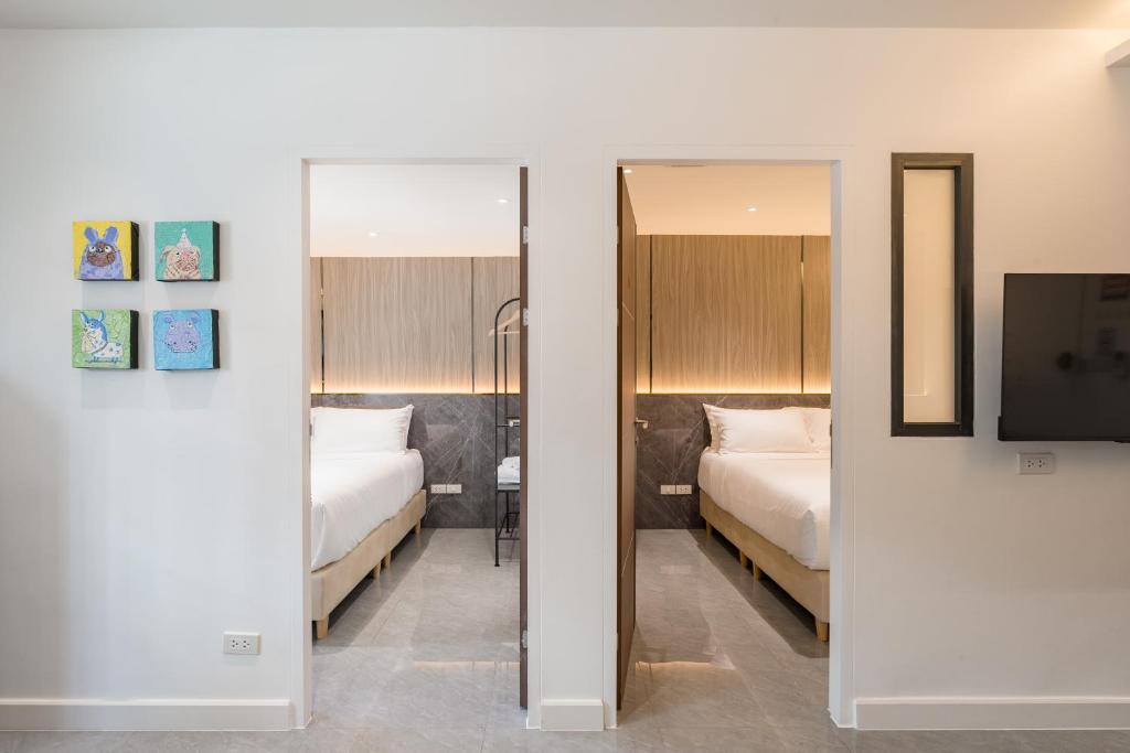 a hotel room with two beds and a mirror at CJ ELAND Sukhumvit36 BTS Thonglor in Klong Toi