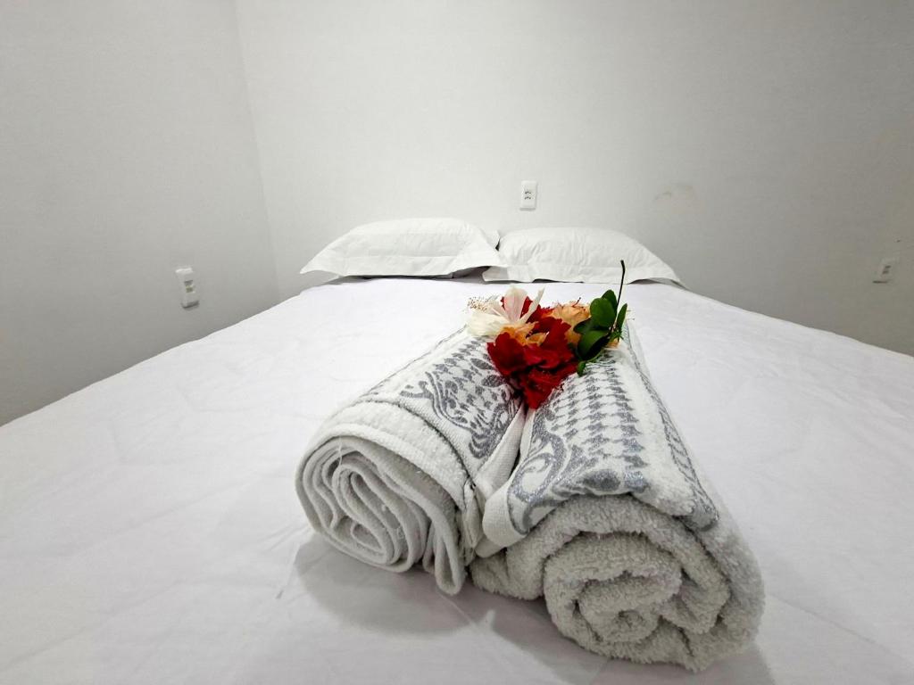 a white bed with a blanket and flowers on it at Recanto de Boipeba in Ilha de Boipeba