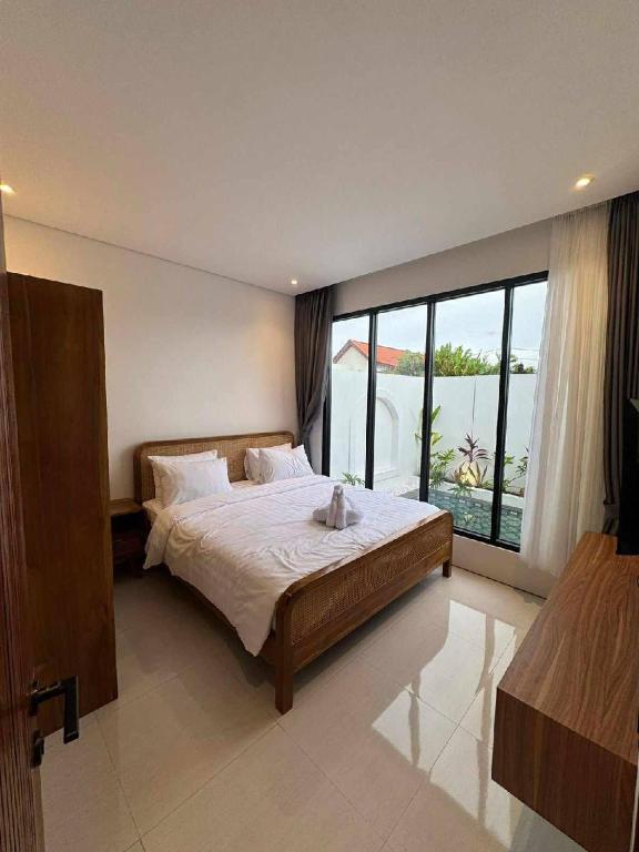 a bedroom with a large bed and a large window at Alijul Private villa in Munggu