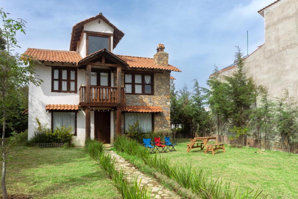 a house with a table and chairs in the yard at Cabaña El Sitio in Huasca de Ocampo