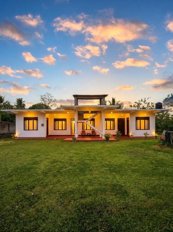 a house with a green lawn in front of it at Willow Nest Inn in Mahiyangana