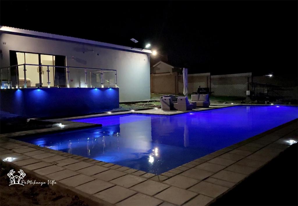 a swimming pool at night with blue lights at Holiday Villa Marondera in Marondera