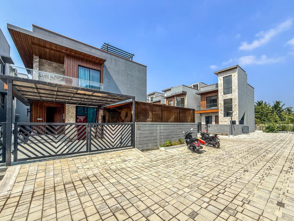 a house with a motorcycle parked in front of it at SeaLara Resorts in Covelong