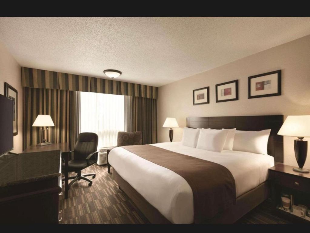 a hotel room with a large bed and a desk at Derby Hotel & Suites in Clarksville