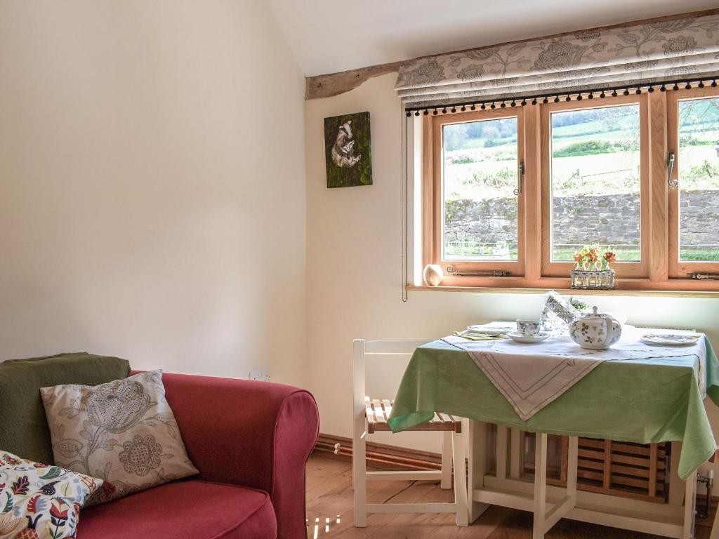 a living room with a table and a chair at Badgers Den - Uk32084 in Dorstone