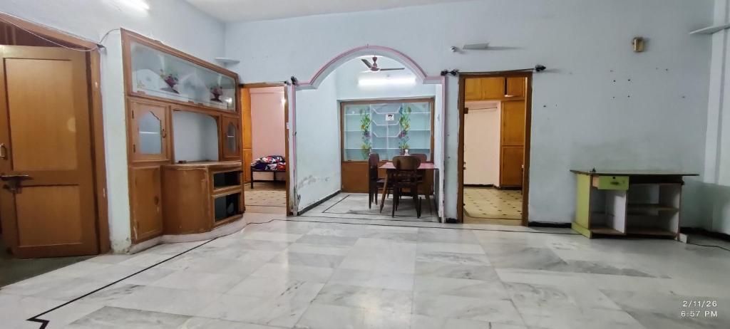 an empty room with a table and some doors at Kurnool Homestay in Kurnool