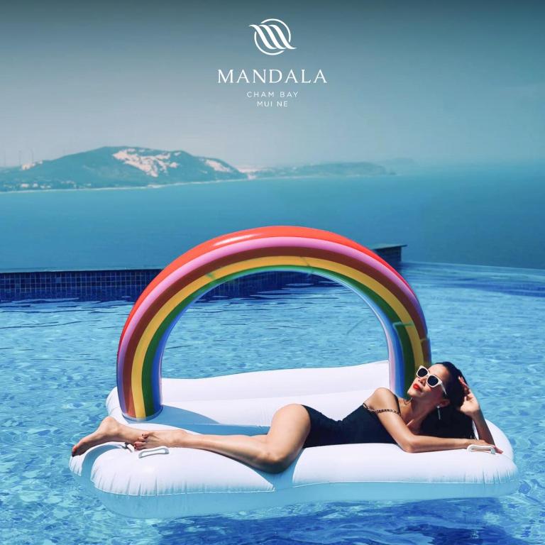 a woman laying on a raft in a swimming pool at Mandala Casa del Sol Mũi Né in Mui Ne